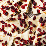 White chocolate bars with cranberries on a wooden surface